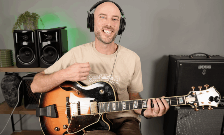 Glen Hitchon playing a jazz guitar, smiling during a YouTube video recording session